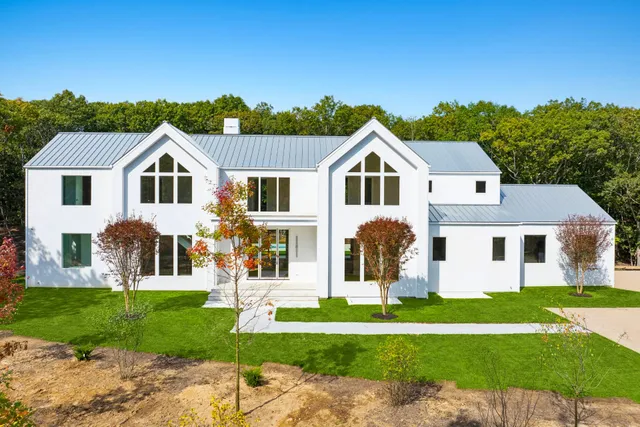 a front view of a house with a garden and plants