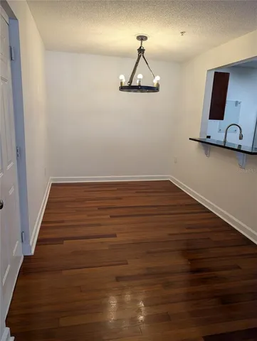 a view of a room with wooden floor and a table