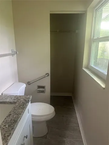 a bathroom with a granite countertop toilet and a sink