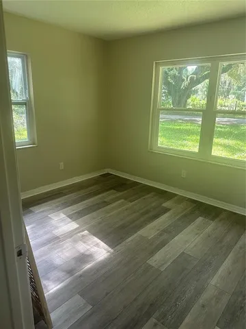 a view of a room with wooden floor and a window