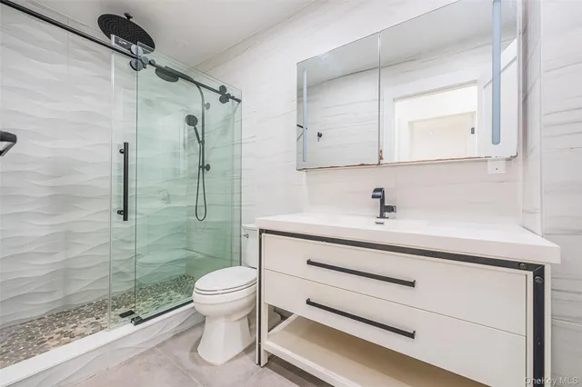 a bathroom with a sink a toilet and shower