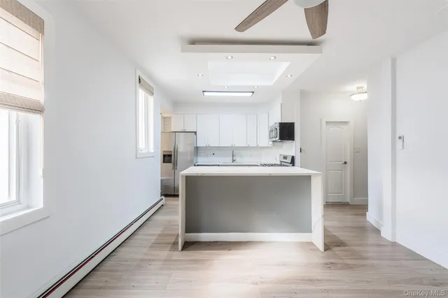 a view of kitchen with stainless steel appliances cabinets and wooden floor