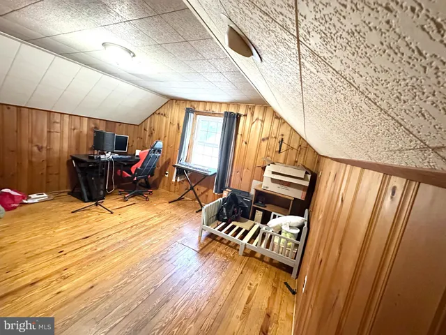 a view of a hallway with wooden floor and furniture