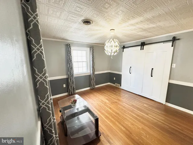 a view of a room with gym equipment and wooden floor