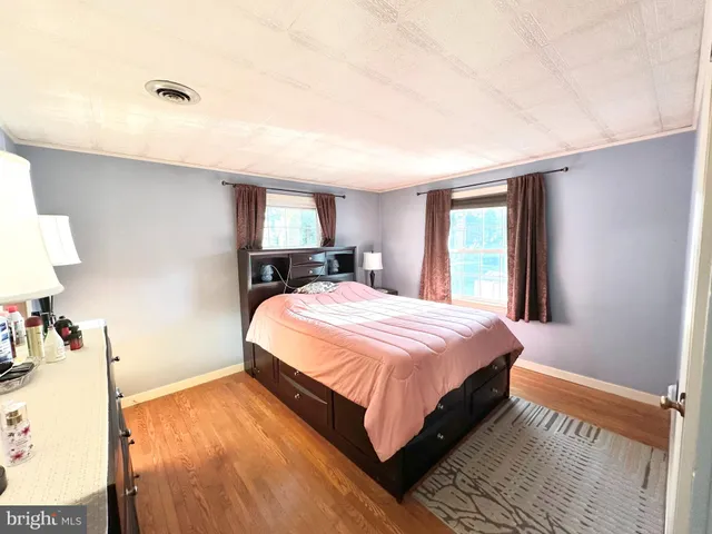 a spacious bedroom with a bed and a lamp on table