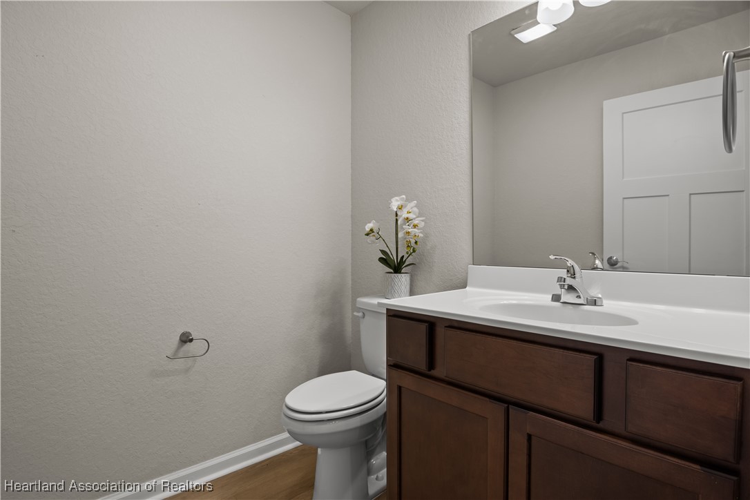 260 Spanish Moss Circle, Unit 101 Sebring, FL 33876 - Photo 12 of 35 a bathroom with a sink a toilet and mirror