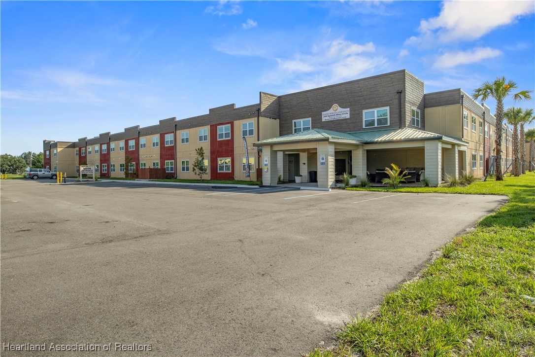 260 Spanish Moss Circle, Unit 101 Sebring, FL 33876 - Photo 13 of 35 a front view of a building with a garden and plants