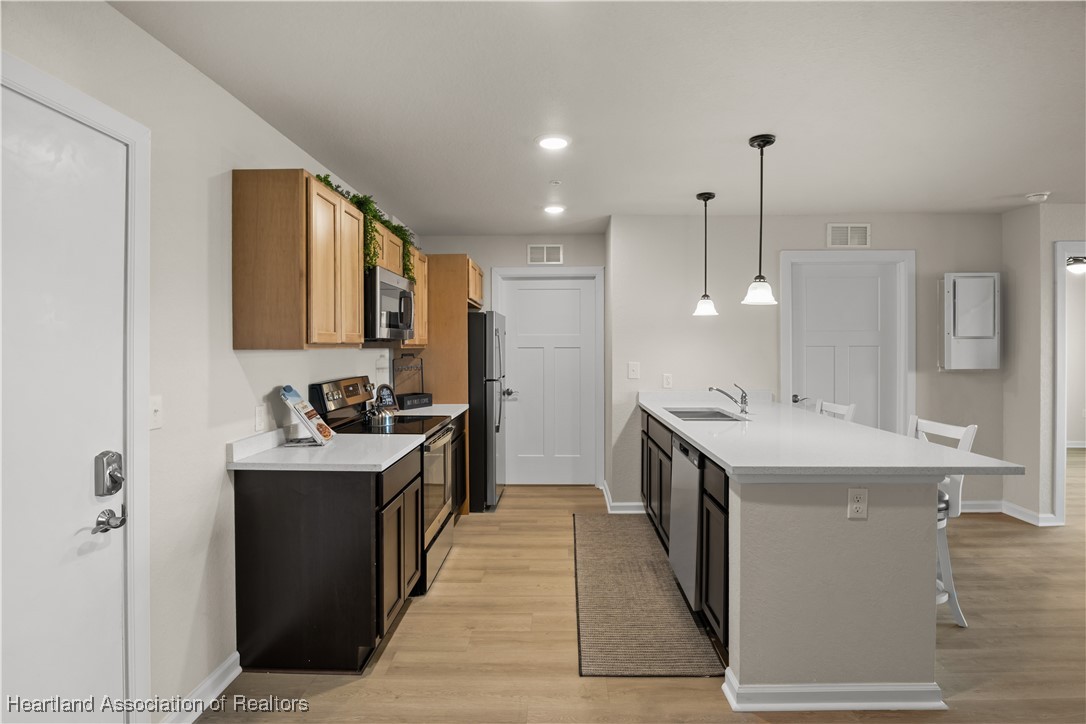 260 Spanish Moss Circle, Unit 101 Sebring, FL 33876 - Photo 3 of 35 a kitchen with granite countertop a sink and a refrigerator