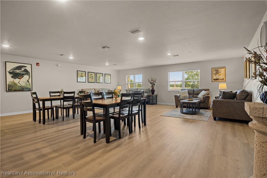 260 Spanish Moss Circle, Unit 101 Sebring, FL 33876 - Photo 32 of 35 a living room with furniture a dining table and a wooden floor