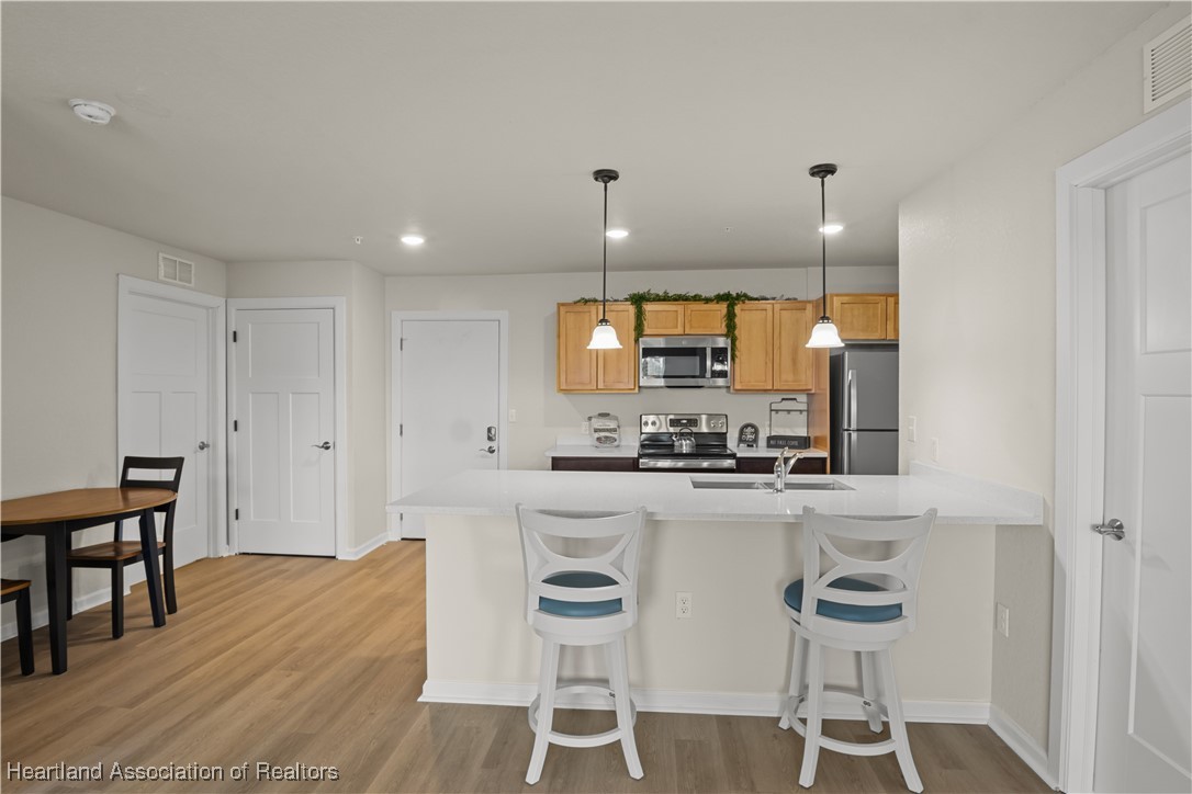 260 Spanish Moss Circle, Unit 101 Sebring, FL 33876 - Photo 4 of 35 a kitchen with stainless steel appliances kitchen island granite countertop a stove a sink and a refrigerator
