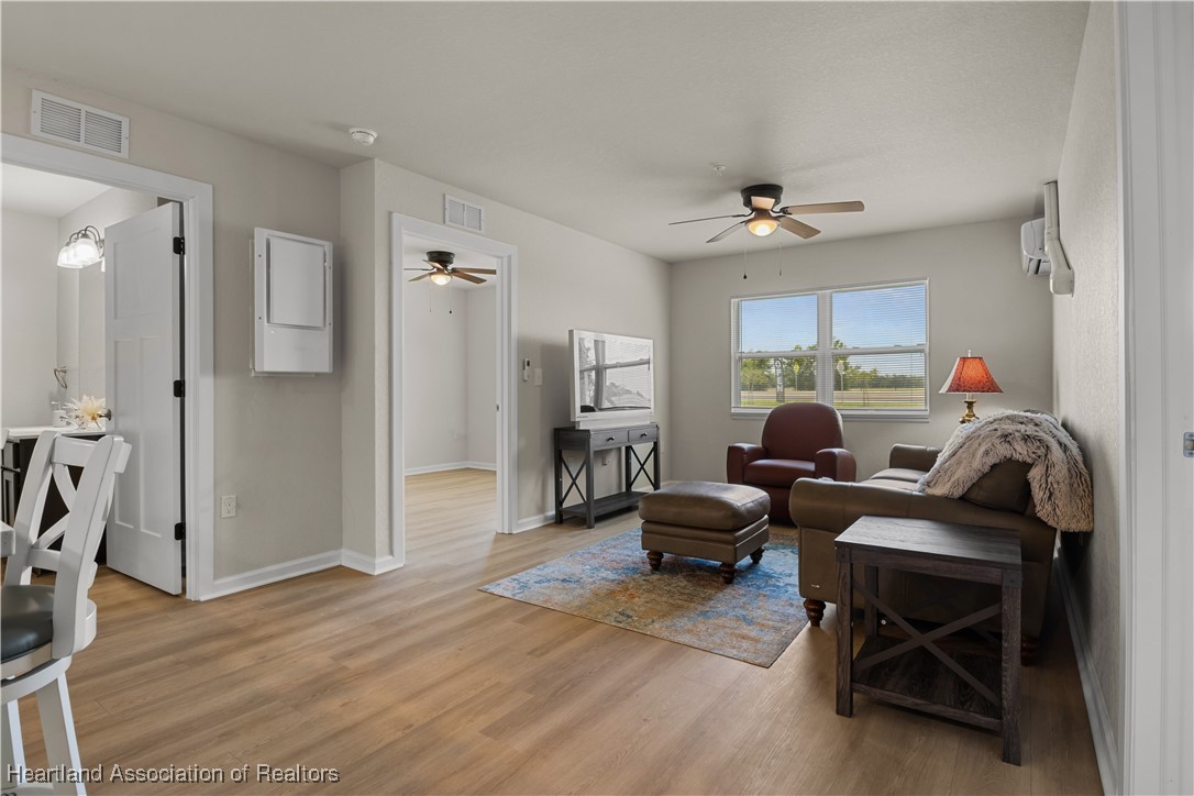 260 Spanish Moss Circle, Unit 101 Sebring, FL 33876 - Photo 5 of 35 a living room with furniture a ceiling fan and a wooden floor