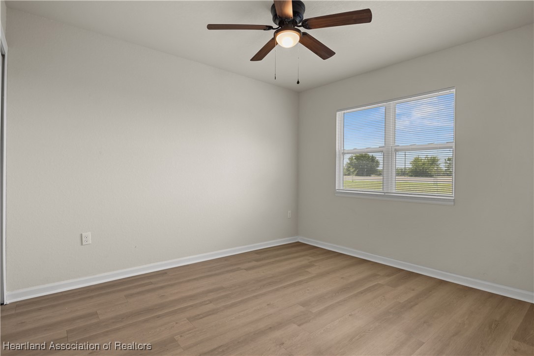 260 Spanish Moss Circle, Unit 101 Sebring, FL 33876 - Photo 6 of 35 a view of empty room with wooden floor and fan