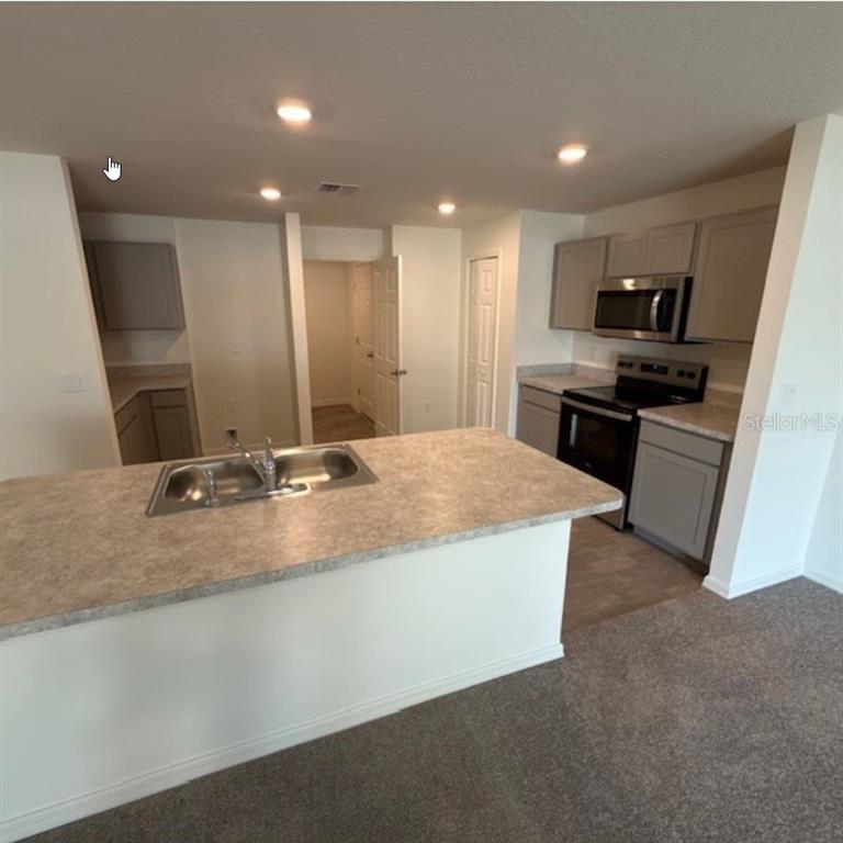 31 Pine Cedar Drive Palm Coast, FL 32164 - Photo 3 of 15 a large kitchen with a sink and a refrigerator