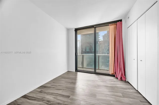 a view of a room with wooden floor and glass door