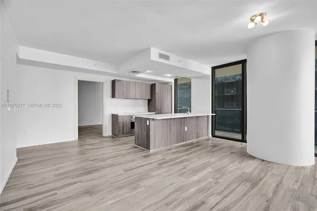 a view of kitchen with wooden floor and electronic appliances