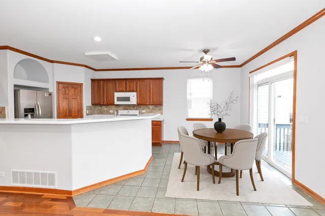 a kitchen with stainless steel appliances a dining table chairs and a refrigerator