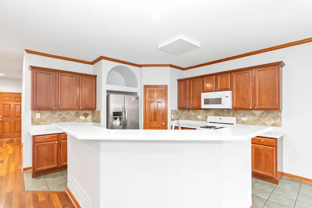 a kitchen with stainless steel appliances granite countertop a sink and a refrigerator
