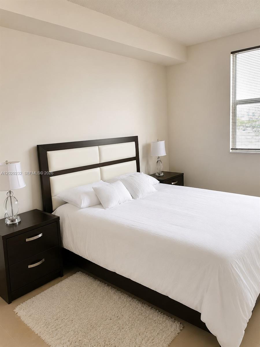 17100 North Bay Road, Unit 1605 Sunny Isles Beach, FL 33160 - Photo 13 of 52 a bedroom with a bed and a night stand