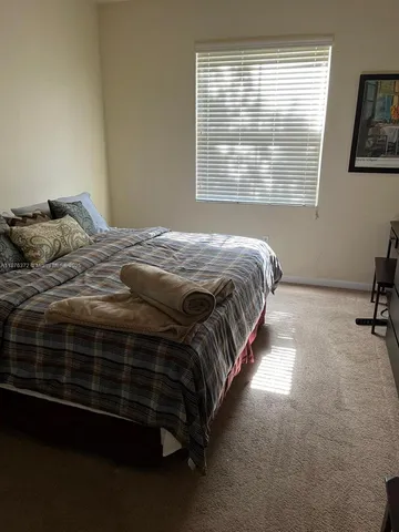 a bedroom with a bed next to a window