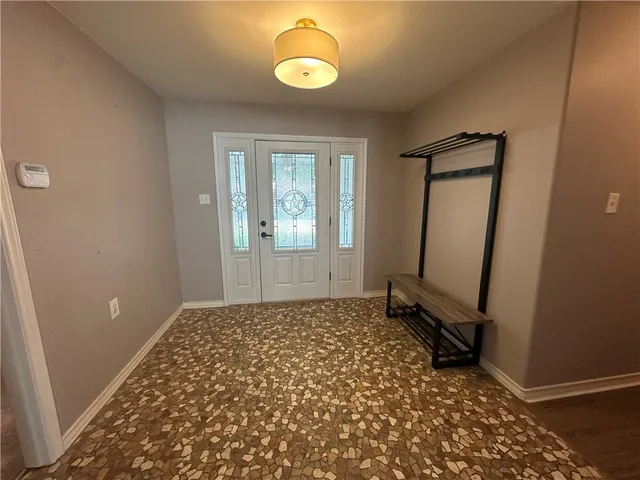 an empty room with mirror and a window