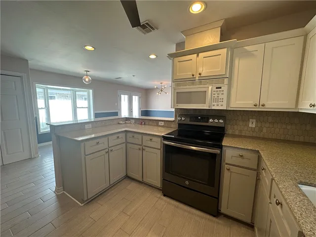 a kitchen with stainless steel appliances granite countertop a stove and a sink