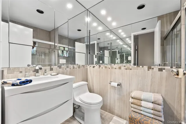 a bathroom with a sink vanity mirror and toilet