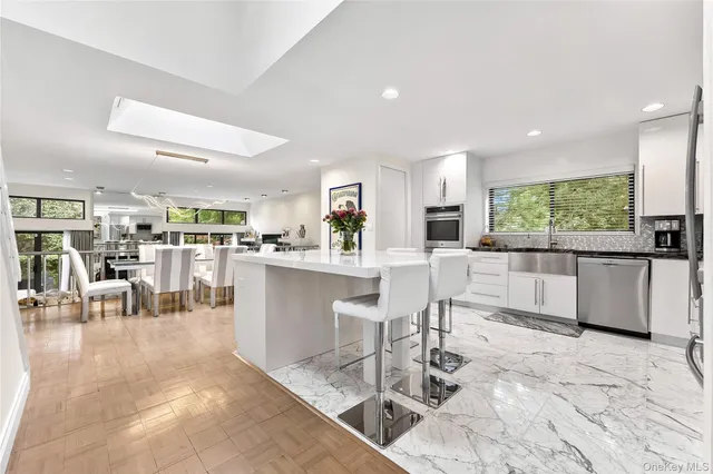 a kitchen with stainless steel appliances kitchen island granite top and refrigerator