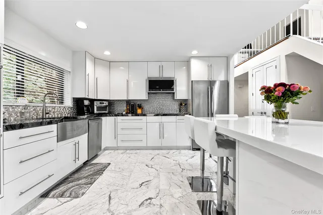 a kitchen with granite countertop a stove a sink and a refrigerator