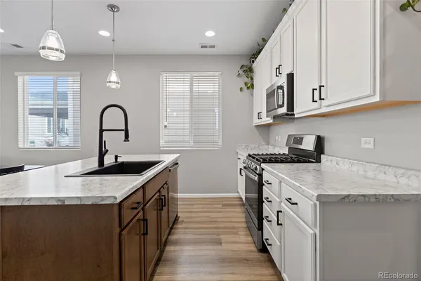 a kitchen with stainless steel appliances granite countertop a sink stove and cabinets