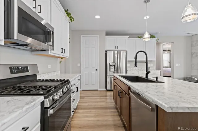 a kitchen with stainless steel appliances granite countertop a stove and a microwave