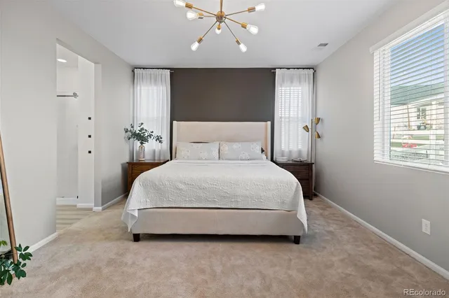 a spacious bedroom with a bed and a chandelier