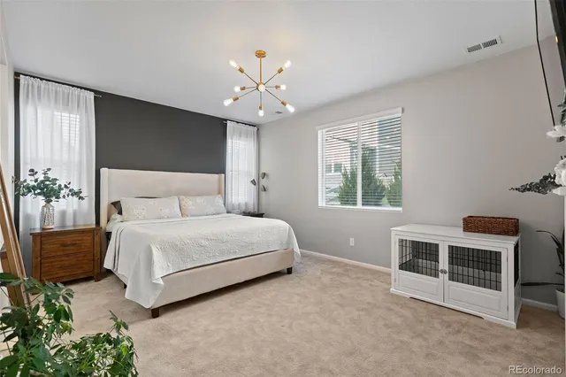 a bedroom with a large bed and a chandelier