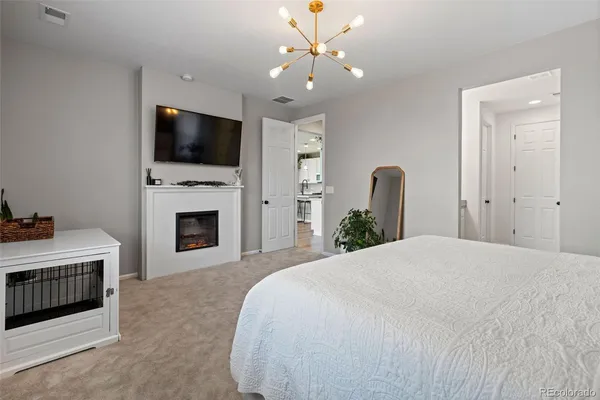 a spacious bedroom with a bed and a flat screen tv