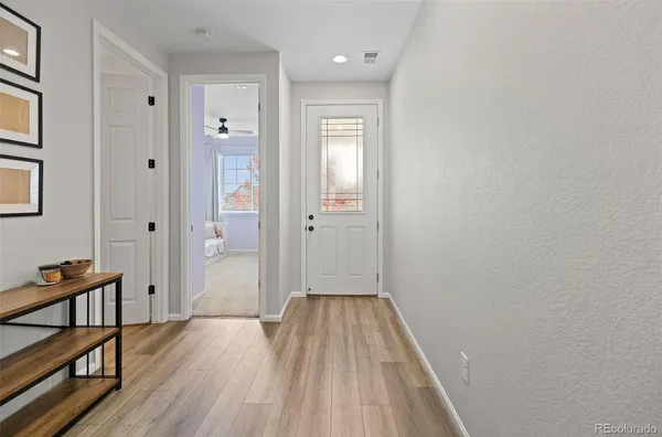 a view of a hallway with wooden floor and staircase