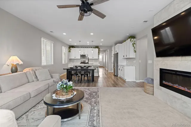 a living room with furniture a flat screen tv and a fireplace