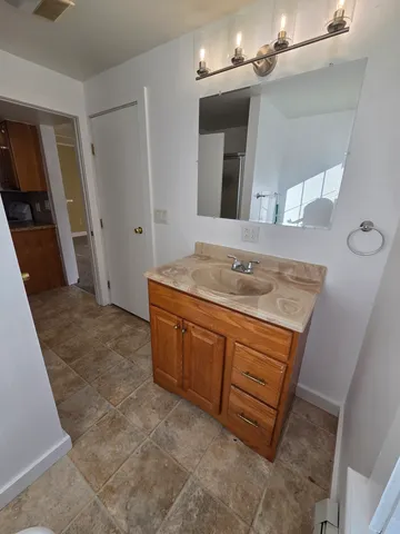 a bathroom with a granite countertop sink a mirror and vanity