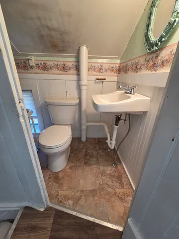 a bathroom with a sink toilet and mirror