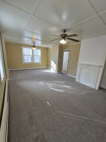 a view of a livingroom with a ceiling fan and window