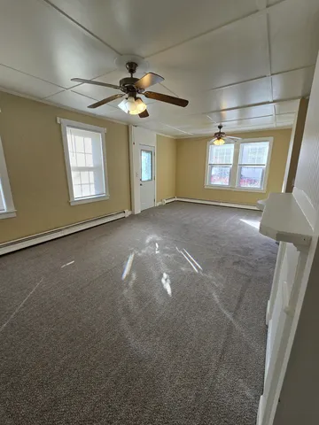 a view of a livingroom with a ceiling fan and window