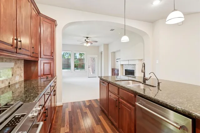 a kitchen with granite countertop a stove a sink and a microwave