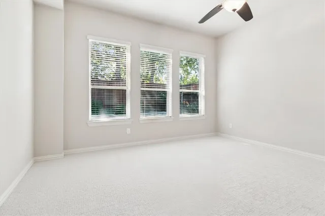 an empty room with chandelier fan
