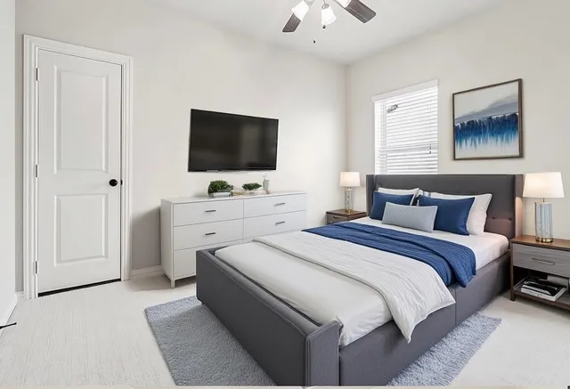 an empty room with a chandelier fan and windows