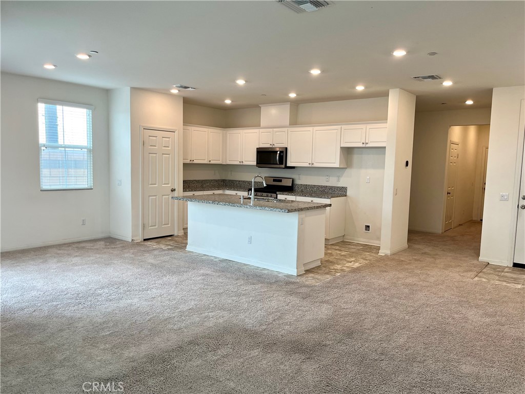1586 Redwoods Drive Place Upland, CA 91784 - Photo 7 of 18 a kitchen with kitchen island a sink stainless steel appliances and cabinets