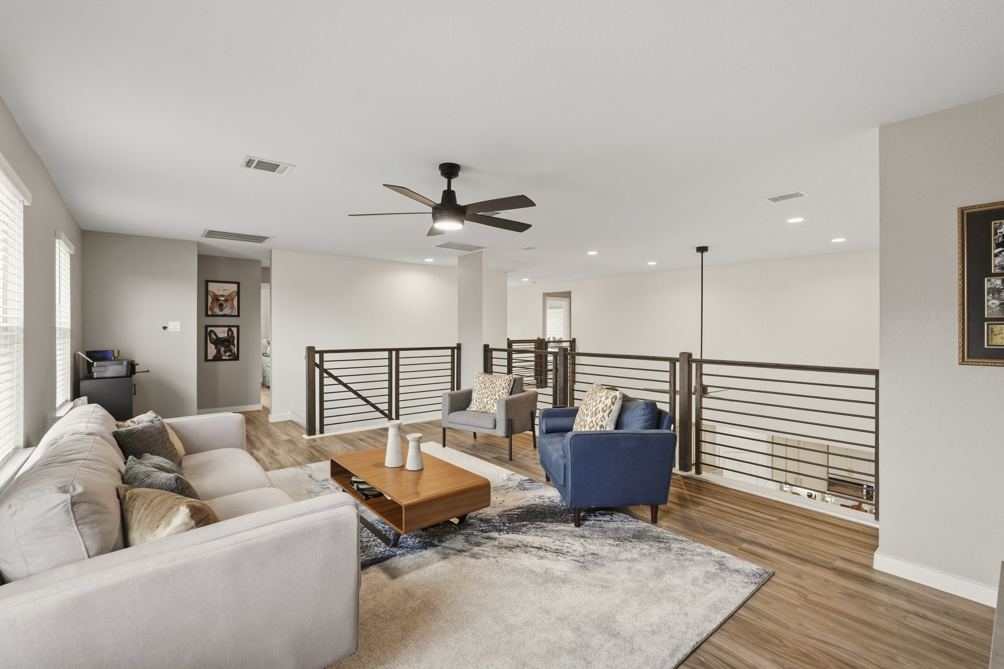 22522 Modica Rift Lane Katy, TX 77449 - Photo 25 of 38 A second look at the upstairs loft reveals just how much space this home truly offers. Bright, open, and versatile, this room can easily flex from a dedicated game room to a secondary living area, study lounge, or playroom. Natural light streams in from multiple windows, the stylish catwalk railing frames the view to the living room below, and the warm hardwood-style floors carry the design language of the whole home seamlessly upstairs.