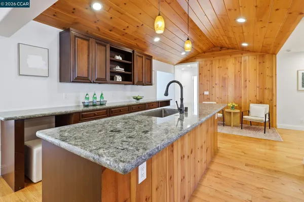 a kitchen with stainless steel appliances granite countertop a sink a stove and a wooden floors