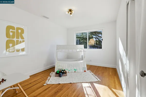 a bedroom with a bed and a dresser next to a window