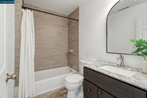 a bathroom with a granite countertop sink toilet and shower
