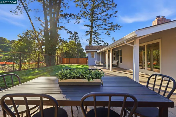 a view of a patio with table and chairs with wooden floor and plants