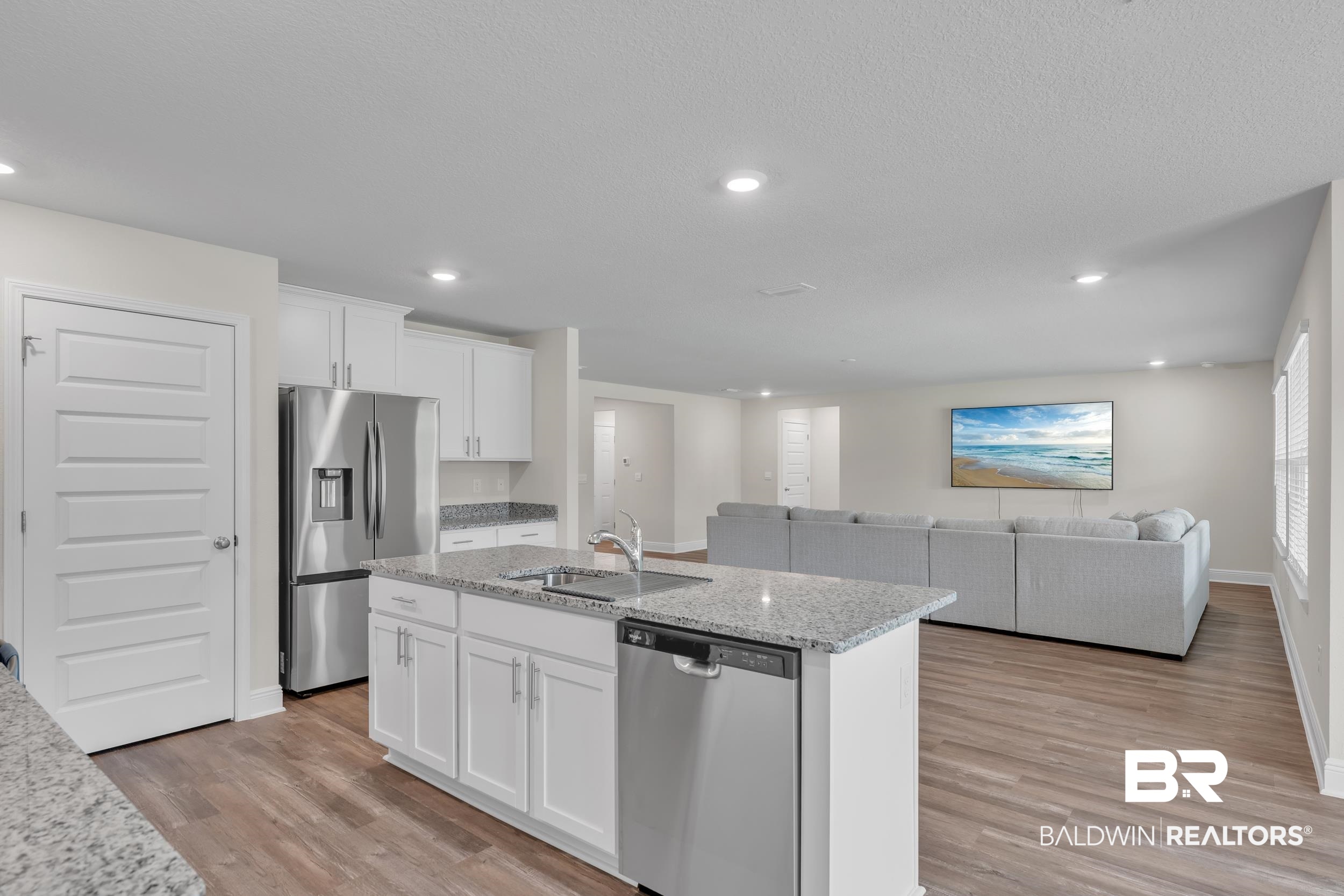 24460 Ringneck Loop Elberta, AL 36530 - Photo 22 of 46 Kitchen with a sink, light wood-type flooring, white cabinetry, appliances with stainless steel finishes, and an island with sink