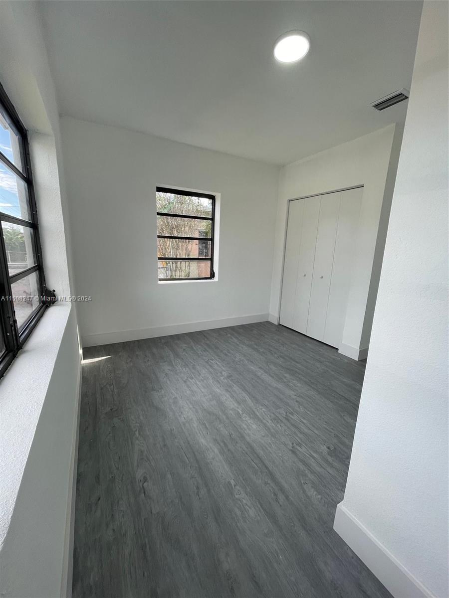 50 East 13th Street Hialeah, FL 33010 - Photo 11 of 17 an empty room with wooden floor and windows